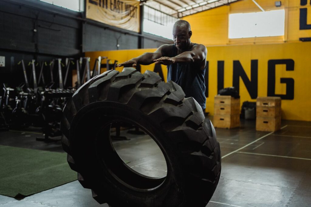 Crafting Captivating Headlines: Your awesome post title goes here Man engaged in flipping tire exercise at gym, showcasing strength and fitness.